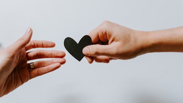 passing black heart cutout to show commitment